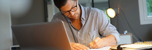 Man looking down at his accounting work at desk.