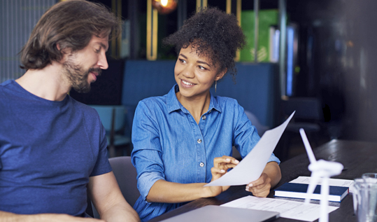 Man and woman studying document for email campaign.